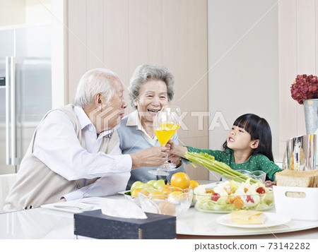happy granddaughter toasting with grandma and grandpa 73142282