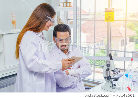 Doctor and microbiologist with vacuum tubes for samples with COVID 19 infection atypical pneumonia virus in laboratory Doctor and microbiologist with vacuum tubes for samples with COVID 19 infection atypical pneumonia virus in laboratory 73142501