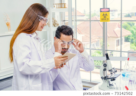 Doctor and microbiologist with vacuum tubes for samples with COVID 19 infection atypical pneumonia virus in laboratory Doctor and microbiologist with vacuum tubes for samples with COVID 19 infection atypical pneumonia virus in laboratory 73142502