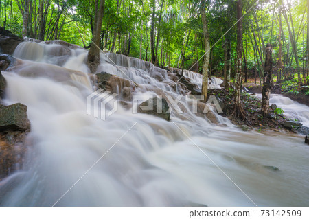 Waterfall scene at Pha Tad Waterfalls in rainforest at the Khuean Srinagarindra National Park Kanchanaburi. Waterfall scene at Pha Tad Waterfalls in rainforest at the Khuean Srinagarindra National Park Kanchanaburi. 73142509