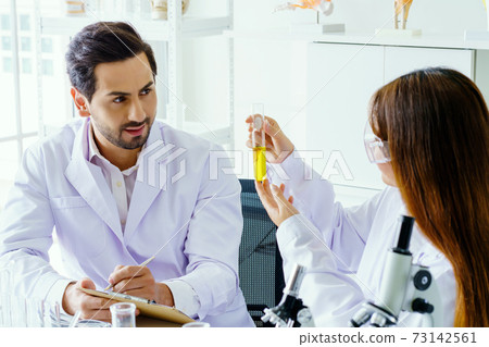 Doctor and microbiologist with vacuum tubes for samples with COVID 19 infection atypical pneumonia virus in laboratory Doctor and microbiologist with vacuum tubes for samples with COVID 19 infection atypical pneumonia virus in laboratory 73142561