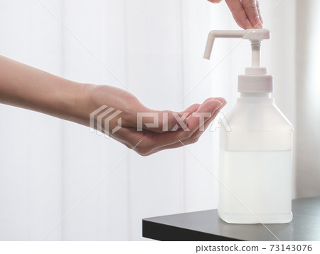 A state of disinfecting hands with an alcohol disinfectant spray. Measures against the new coronavirus COVID-19. 73143076