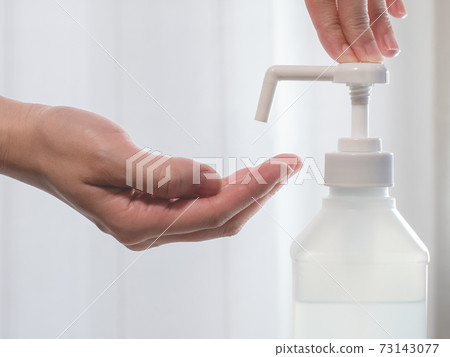 A state of disinfecting hands with an alcohol disinfectant spray. Measures against the new coronavirus COVID-19. 73143077