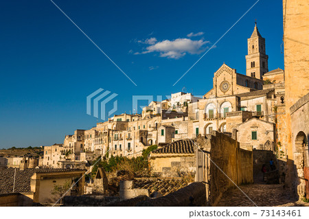 Cave dwelling and Matera cathedral seen from the alley of Matera, Italy Cave dwelling and Matera cathedral seen from the alley of Matera, Italy 73143461
