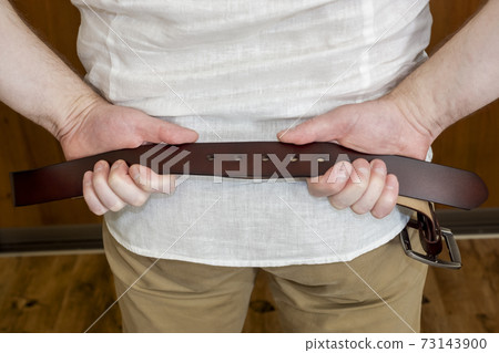 A strict father with a leather belt will chastise his son A strict father with a leather belt will chastise his son 73143900