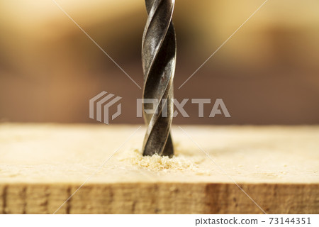 Closeup of wood drill bit with sawdust Closeup of wood drill bit with sawdust 73144351