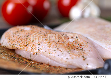 raw chicken breast with spices prepared for roasting raw chicken breast with spices prepared for roasting 73144410