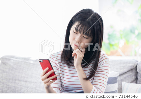 女孩看著智能手機和思考 73144540