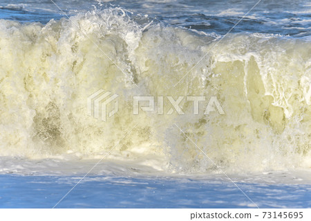 Waves breaking on the beach at the edge of the Atlantic Ocean. 73145695