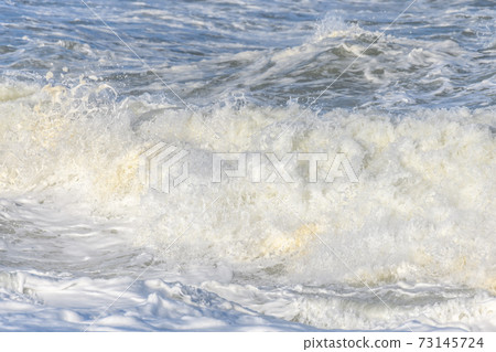 Waves breaking on the beach at the edge of the Atlantic Ocean. 73145724