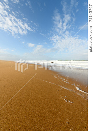 Beautiful sandy beach along the Atlantic Ocean in the early morning light. Beautiful sandy beach along the Atlantic Ocean in the early morning light. 73145747