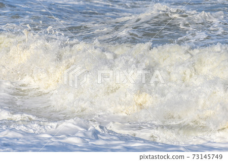 Waves breaking on the beach at the edge of the Atlantic Ocean. 73145749