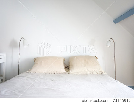 Bed and lamp in a white bedroom Bed and lamp in a white bedroom 73145912