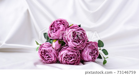 Bouquet of beautiful violet peonies on white silk fabric background. Copy space. Greeting card Bouquet of beautiful violet peonies on white silk fabric background. Copy space. Greeting card 73146759