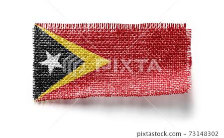 East Timor flag on a piece of cloth on a white background 73148302