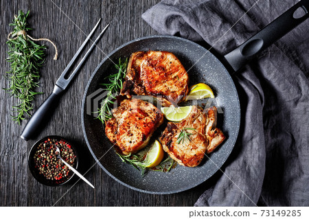 fried pork chops on a skillet, top view fried pork chops on a skillet, top view 73149285
