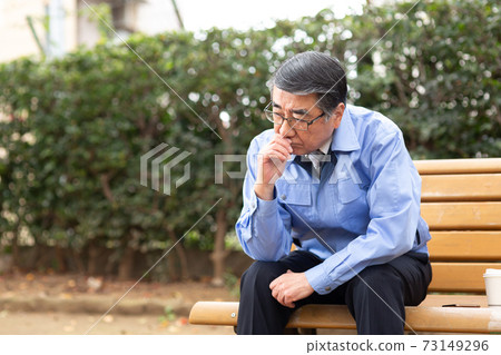 坐在公園的長椅上的工作服的男人 坐在公園的長椅上的工作服的男人 73149296