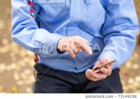 看著鞦韆上的智能手機的男士零件 看著鞦韆上的智能手機的男士零件 73149298