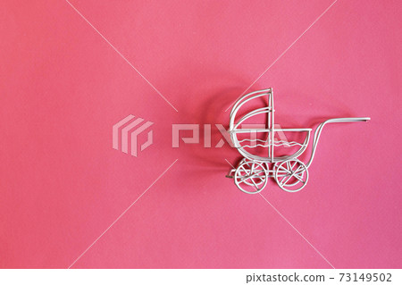 vintage toy baby stroller on pink background. toy carriage vintage toy baby stroller on pink background. toy carriage 73149502