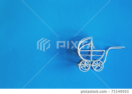 vintage toy baby stroller on blue background. toy carriage vintage toy baby stroller on blue background. toy carriage 73149503