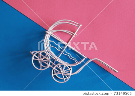 vintage baby stroller on pink and blue background. Boy or girl question 73149505