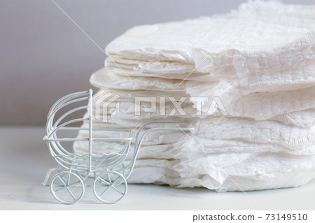 Baby diapers with toy carriage on a white background 73149510
