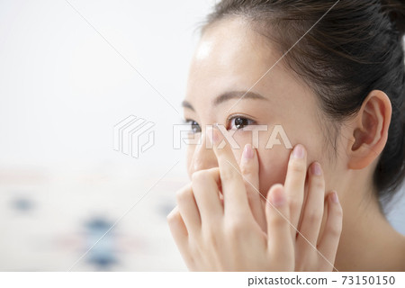 放入隱形眼鏡的年輕女子 放入隱形眼鏡的年輕女子 73150150
