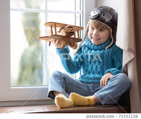 Happy child playing with toy airplane at home 73151138
