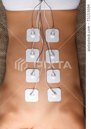 Muscle stimulator with electrodes, bacBack and shoulder massage with a muscle stimulator with attached electrodes along the spine. 73153094