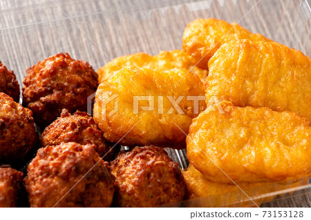 Takeout image. Deep-fried chicken nuggets and meatballs in a clear plastic container. Takeout image. Deep-fried chicken nuggets and meatballs in a clear plastic container. 73153128
