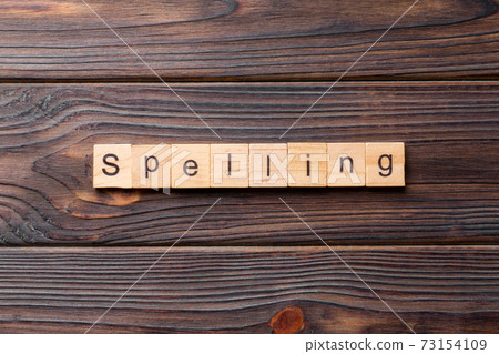 spelling word written on wood block. spelling text on cement table for your desing, concept 73154109