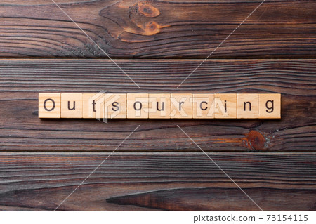 outsourcing word written on wood block. outsourcing text on table, concept 73154115