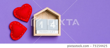 Top view of wooden calendar and textile hearts on colorful background. The fourteenth of February. Valentine's day concept 73154425