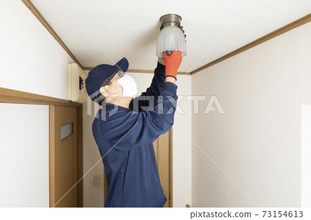 House cleaning male worker replacing light bulbs House cleaning male worker replacing light bulbs 73154613