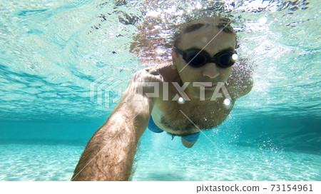Caucasian man swimming under the water 73154961
