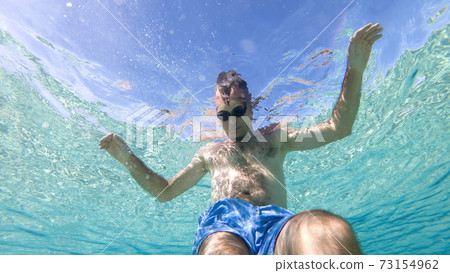 Caucasian man swimming under the water 73154962