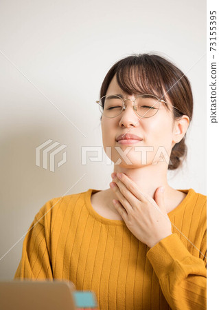 A young woman with a sore throat due to hay fever 73155395