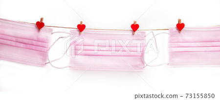 Pink protective medical mask hanging with clothes pegs in heart shape isolated on white background, Health, Covid-19 or Valentine's Day concept background Pink protective medical mask hanging with clothes pegs in heart shape isolated on white background, Health, Covid-19 or Valentine's Day concept background 73155850