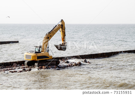 excavator during the construction of a breakwater excavator during the construction of a breakwater 73155931