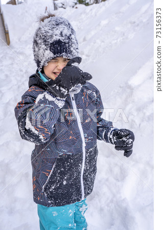 Boy playing in the snow. Cold snowy winter. Happy childhood Boy playing in the snow. Cold snowy winter. Happy childhood 73156373