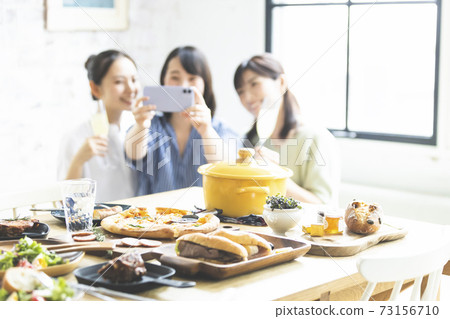 Woman taking a selfie at a home party 73156710