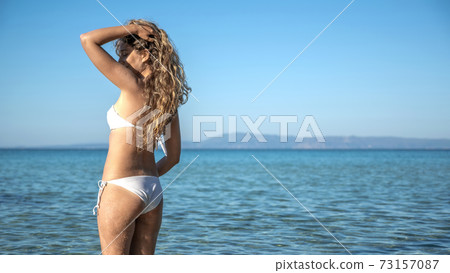 A woman on the beach in Greece 73157087
