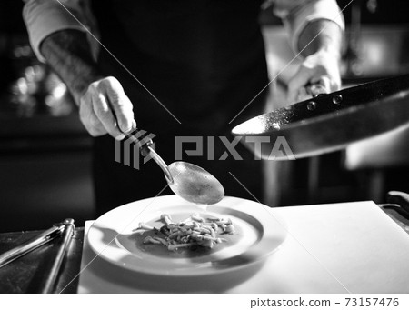 Chef cooking in a kitchen, chef at work, Black and White. Chef cooking in a kitchen, chef at work, Black and White. 73157476