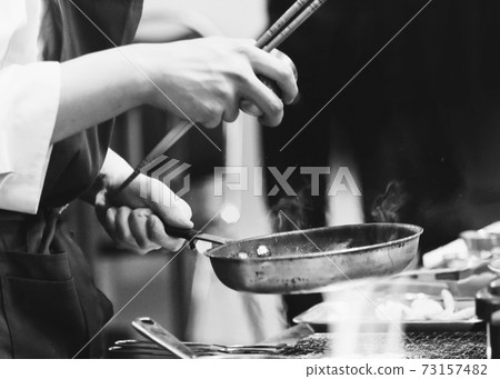 Chef cooking in a kitchen, chef at work, Black and White. Chef cooking in a kitchen, chef at work, Black and White. 73157482