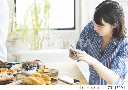 一個用智能手機拍照的女人 73157694