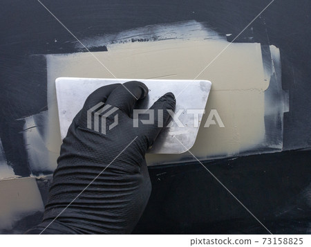 technology of applying automotive putty on a repair part. 73158825