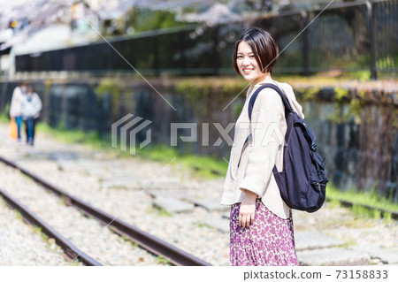 A woman watching cherry blossoms at Keage Incline during sightseeing in Kyoto 73158833