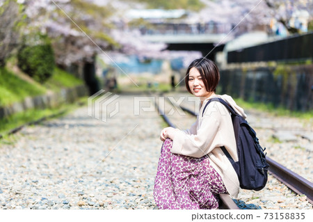 A woman sitting on the Incline railroad tracks during spring sightseeing in Kyoto A woman sitting on the Incline railroad tracks during spring sightseeing in Kyoto 73158835