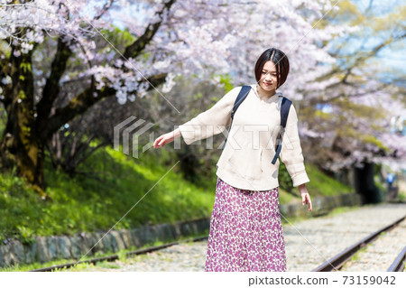 A woman watching cherry blossoms at Keage Incline during sightseeing in Kyoto A woman watching cherry blossoms at Keage Incline during sightseeing in Kyoto 73159042