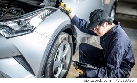 Asian auto mechanic checking the car wheel using tablet Asian auto mechanic checking the car wheel using tablet 73159339